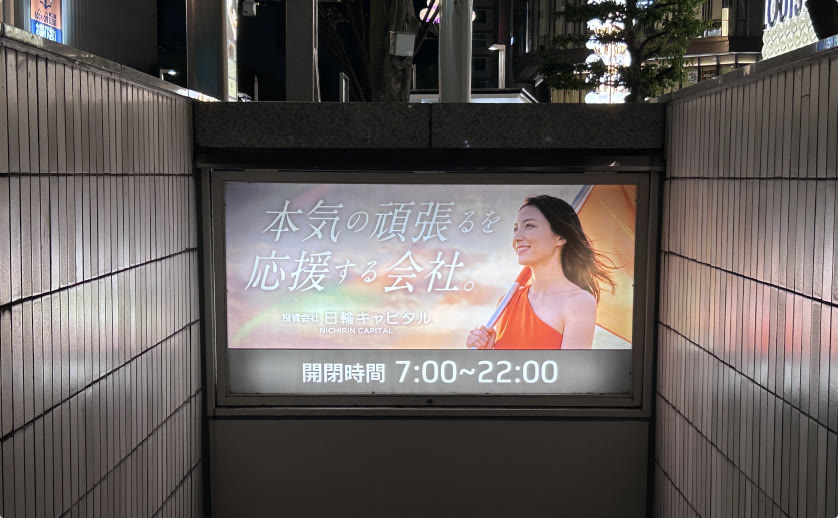 サカエチカ地上出入口の広告「本気の頑張るを応援する会社。」